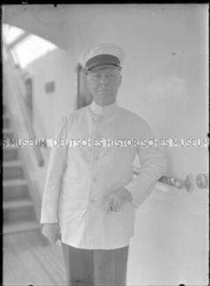 Herr in weißer Uniform (Bordstuart) an Deck des Hochseepassagierdampfers "Bremen"