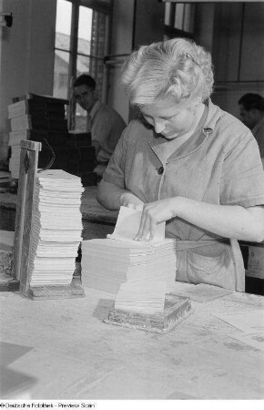 Buchbinderin beim Einbinden eines Buches