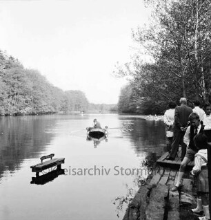 Kupfermühle: Kupfermühlenteich: rechts Bootsanleger mit Ausflüglern: links im Wasser kleiner Steg der Bootsvermietung: in der Mitte Ruderboot mit Ausflüglern: hinten Wald