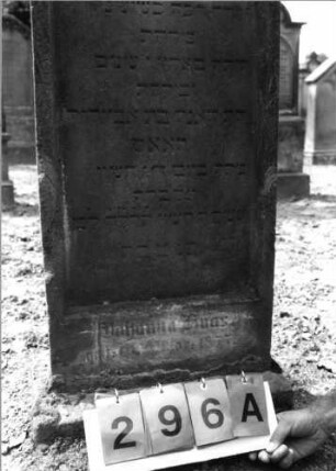 Grabstein 296 (Index: 99797838) Material: Sandstein, weiß Zustand: stark verwittert Maße HxBxT: 97x47x11 cm Beschreibung: Stele, giebelartiger Abschluß abgeflacht, Sockel: Grabstein 296A