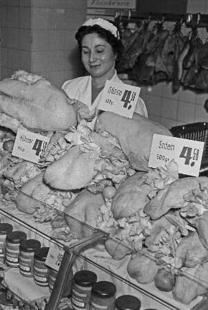 Konsum-Verkaufsstelle. Verkäuferin hinter einer Kühltheke mit Geflügel, 1956.