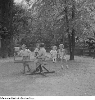 Kinder auf einem Karussell auf einem Spielplatz im im Clara-Zetkin-Park