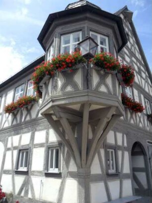 Rathaus (erbaut 1666)-Ansicht über Eck mit Eckerker im Obergeschoß in Fachwerk auf Knaggen im Detail