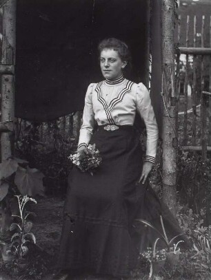 Junge Frau vor einer Gartenlaube