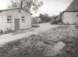 Reinholdshain (Kreis Dippoldiswalde). LPG Pflanzenproduktion Reinholdshain. Dunganlage gegen Wirtschaftsgebäude und Traktor