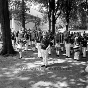 Schützenfest: Veranstalter Bürgerschützengilde von 1627 e.V. Bad Oldesloe: Bürgerpark, Weg zur Stormarnhalle: Oldesloer Spielmannszug spielt Ständchen, zwei Tambourmajore, Fahne "SMZ Bad Oldesloe: Bäume: hinten rechts Stormarnhalle, links Exer, 29. Juli 1973