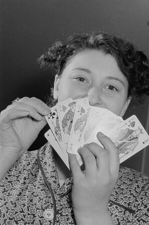 Eine Frau präsentiert Spielkarten aus der Altenburger Spielkartenfabrik