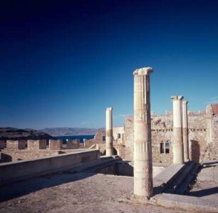 Lindos (Rhodos). Burgzinnen und antike Säulen vom Heilligen Bezirk der AO Akropolis hadia; OH 66