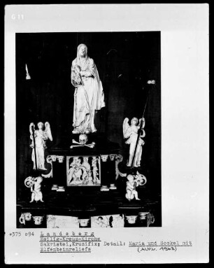 Figur der trauernden Maria am Sockel eines Kruzifix