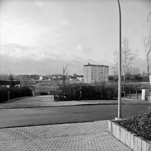 Masurenweg: Blick Richtung Südwesten: hinten Hochhaus an Straße Stoltenrieden: im Vordergrund Auffahrt, Straßenlampe: gegenüber Einfahrt