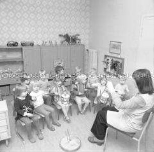 Erzieherin bei musikalischer Früherziehung mit Schlaginstrumenten im Kindergarten in der Dregerhoffstraße in Berlin-Köpenick