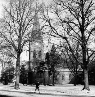 Martin-Luther-Kirche: Kirchhof mit Bäumen: vorn Kirchenstraße mit Fußgänger: Winter