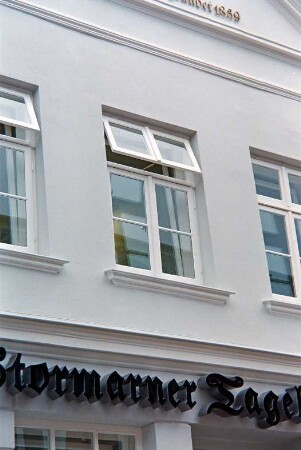Mühlenstraße 21: giebelständiges Wohn- und Geschäftshaus: nach Sanierung: Straßenfront: Teilansicht: Fenster in Obergeschoss: darunter Firmenschild Stormarner Tageblatt