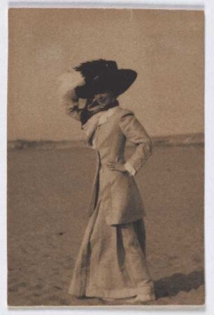 Junge Dame mit großem Hut am Strand, de profil