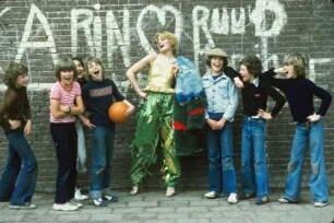 Aufnahme für die Reportagereihe „Außenseiter der Mode“: Studio Fong Leng, Amsterdam : Model in gelbem Top und grünen Pluderhosen nach Entwürfen von Fong Leng, mit einem Basketball und drei Jungs vor einer Graffitiwand