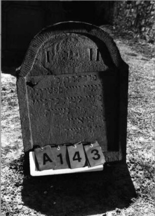Grabstein 143 (Index: 99798047) Material: Sandstein, rot Zustand: stark verwittert Maße HxBxT: 705x0x11 cm Beschreibung: Stele, geschweifter Abschluß: Grabstein 143A