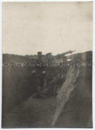 Soldaten im Schützengraben am Geschütz