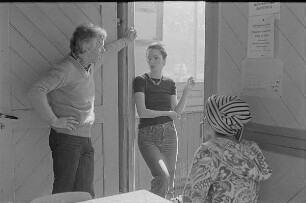 Höfgen. Akt-Pleinair 1979. Die Fotografen Günter Rössler und Eva Mahn im Gespräch, am Tisch sitzt ein Fotomodell mit Turban