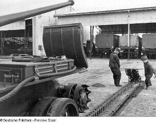 Goldberg (Kreis Lübz). Nationale Volksarmee - Landstreitkräfte. Panzerregiment 8 (PR-8). Freifläche vor Panzerhallen. Soldaten bei Instandsetzungs- bzw. Wartungsarbeiten an Gleisketten für Kampfpanzer T-54