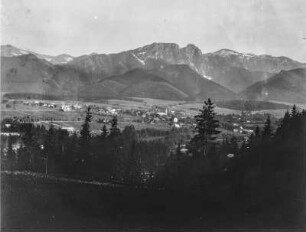 Dorf : Blick in ein Tal mit einem Dorf und hohen Bergen im Hintergrund