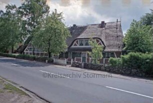 Möllner Landstraße 3: Fachwerkhaus mit Reetdach: traufständige Straßenfront mit Eingangstür und breiter Dachgaube: links daneben Fachwerkhaus mit Reetdach