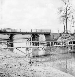 Trave: Brückenneubau: Notsteg, dahinter alte Holzbrücke: rechts Baum