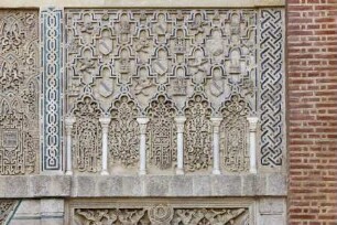 Reliefierte Fassadenzone — Rechtes Relieffeld mit Sebkaornament, fächerbogigen Blendarkaden und Wappensymbolik