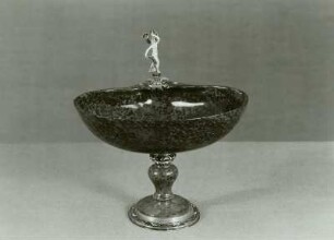 Muschelförmige, ungerippte Schale mit Venus mit Delphin und wehendem Tuch auf dem Rand
