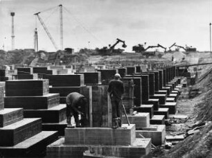Baustelle Kraftwerk Thierbach. Gründungsbau, im Vordergrund zwei Bauarbeiter bei der Montage einer Holzschalung : Thierbach. Baustelle Kraftwerk Thierbach. Gründungsbau, im Vordergrund zwei Bauarbeiter bei der Montage einer Holzschalung