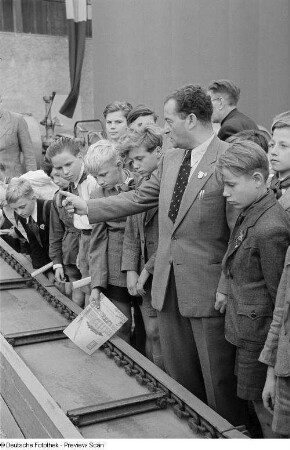 Kinder zu Besuch auf der Leipziger Herbstmesse 1954 an einem Förderband