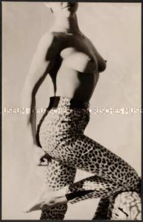 Junge Frau mit nacktem Oberkörper posiert in einer Leopardenfleck-Leggins (Altersgruppe 18-21)