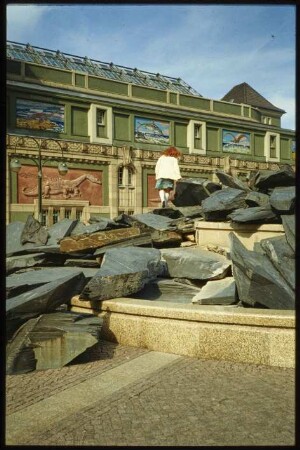 Kind auf dem Ammonitenbrunnen vor dem Aquarium des Berliner Zoos