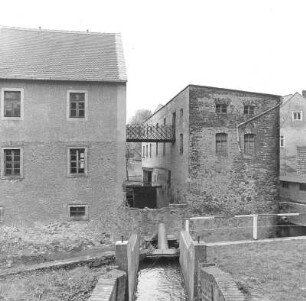 Mutzschen (Grimma-Mutzschen), Mühlgasse 17. Ehem. Mühle (wohl 19. Jh.). Blick über den Mühlgraben mit Verbindungsgang zwischen Wohnhaus und Lagergebäude