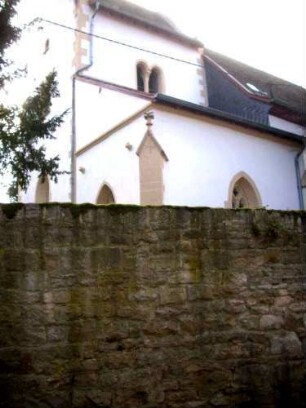 Ansicht von Nordosten mit Kirchturm (Romanische Gründung) und Sakristei (Gotisch gegründet) über Kirchhofmauer von Nordosten