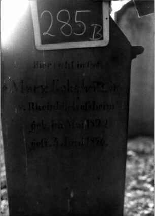 Grabstein 285 (Index: 100111003) Material: Sandstein Zustand: verwittert Maße HxBxT: 134x57x19 cm Beschreibung: Stele, getreppter Sockel, giebelartiger Abschluß, rechteckig erhöht, Schriftfeld eingetieft Symbolik: segnende Hände: Grabstein 285B