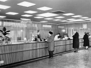 In einer Bank-Filiale. Kunden stehen an Bankschaltern an