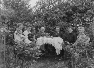 Gruppenaufnahme mit Paul Schulz an einer Kaffeetafel im Garten