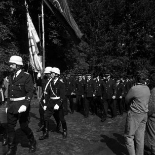 Jersbek: Festplatz: Amtsfeuerwehrfest des Amtes Bargteheide-Land und der Stadt Bargteheide sowie 85-jähriges Jubiläum der Freiwilligen Feuerwehr Jersbek: Festzug der Feuerwehrmannschaften zum Ehrenmal: vorn links Fahnenträger: rechts Zuschauer: im Hintergrund Bäume
