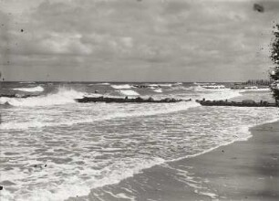 Blick vom Strand gegen Wellenbrecher und Seebrücke in der Ostsee