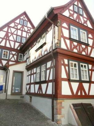 Stadtbild-Kirchenstraße - Gebäudebestand im Norden - Giebelständiges Haus mit Fachwerkobergeschossen auf Steinernem Stock (Riegelbauweise) querab in Übersicht