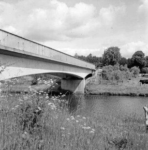 Trave: links Brücke: hinten rechts Weide mit Rinderherde: im Hintergrund kirchturm zwischen Bäumen