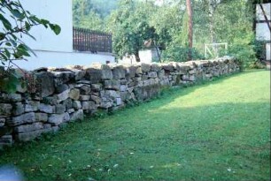 Grundstücksgrenze mit Natursteinmauer als Trockenmauer