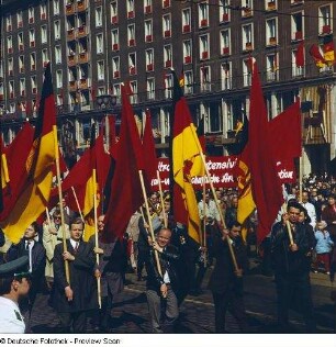 Demonstrationszug zum 1. Mai. Fahnenträger mit Arbeiter- und Staatsfahnen