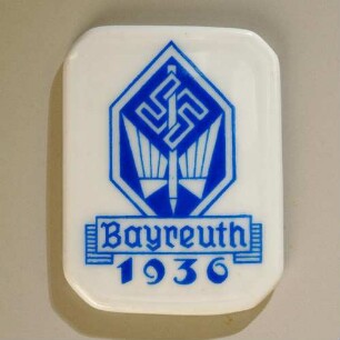 Ereignisplakette Einweihung "Haus der Kurzschrift" in Bayreuth 1936 : Medaillensammlung Stenografische Sammlung. Ereignisplakette Einweihung "Haus der Kurzschrift" in Bayreuth 1936 (geflügelte Feder mit Hakenkreuz und Aufschrift "Bayreuth 1936"; rückseitig: H&Co Selb Bavaria Heinrich&Co.). Porzellan; Maße 42 x 32 mm (1936; Heinrich & Co.). Dresden: SLUB R c 0462