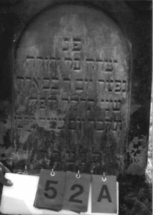 Grabstein 52 (Index: 100113759) Material: Sandstein Zustand: leicht verwittert Maße HxBxT: 90x55x11 cm Beschreibung: Stele mit eingezogenem Spitzgiebel, vertiefter Textteil in Form einer Stele mit Rundbogen: Grabstein 52A