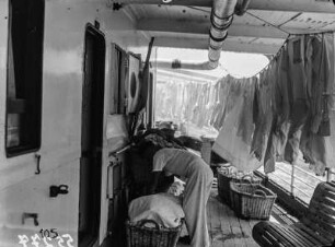 Chinesische Wäscherei an Bord des Dampfers "Usambara" (Deutsche Ost-Afrika-Linie). Wäschereiarbeiter mit Körben und trocknende Wäsche auf einem Seitendeck, 1931
