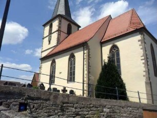 Ansicht von Südosten mit Kirche (Maßwerkfenster sowie Rechteckchor) über Kirchhofmauer in Übersicht