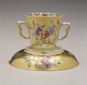 Doppelhenkelbecher und Unterschale mit Goldfond und Blumendekor