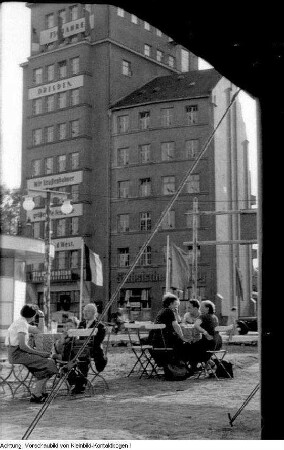 Dresden. 750-Jahr-Feier Dresden, u.a. festliche geschmückte Häuser, Fahnenschmuck auf dem Theaterplatz, Auslage des Café Toscana am Schillerplatz, Platz der Einheit (Albertplatz), Hotelportiers, Andenken, Fahrradtouristen, Richtfest, Modenschau, fahrbahres Postamt, Konzert auf dem Altmarkt, Verkehrsschilder, Juni 1956