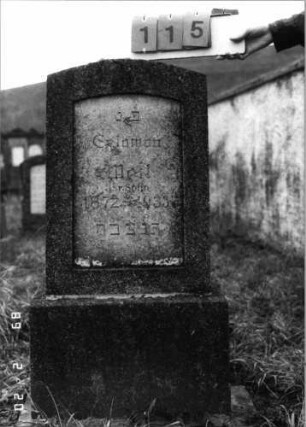 Grabstein 115 (Index: 99798263) Material: Kunststein Zustand: gut Maße HxBxT: 120x50x16 cm Beschreibung: Stele mit Segmentbogenabschluß, Sockel: Grabstein 115